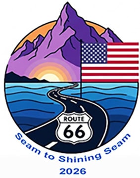 Logo with a winding Route 66 road leading to mountains at sunrise, an American flag on the right, and “Seam to Shining Seam 2026” below—perfect for promoting the Quilt Show in Springfield IL.