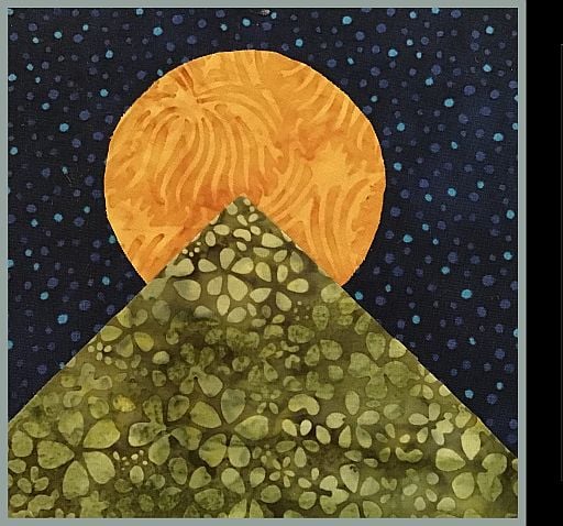 SVQG-Web-Logo A quilt pattern showing a green, flower-patterned pyramid in front of an orange sun against a dark blue, starry sky.