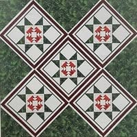 Townsquare-Quiltlovers A quilt pattern with five diamond-shaped blocks, each featuring a red, white, and green geometric star design, set against a green leafy background—perfect for displaying at the Quilt Show in Caldwell OHIO.