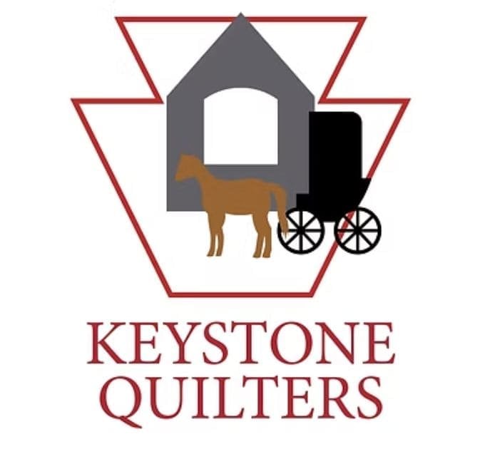 Logo with a red keystone outline, a gray barn, a brown horse, and a black buggy. Below, bold red text reads Keystone Quilters—perfect for representing the Quilt Show in Pennsburg Pennsylvania.